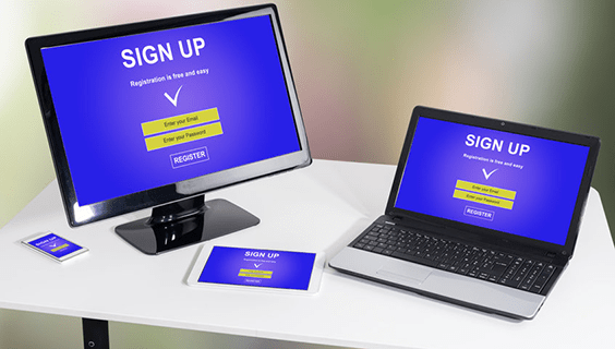 Various electronic devices on a desk showing a sign up web page